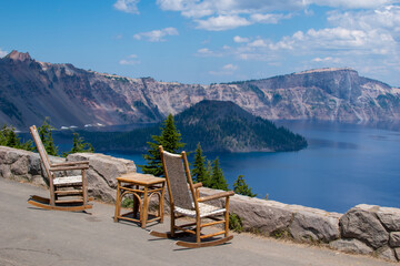 View of Crater Lake from the historic lodge with empty rocking chairs facing the lake.