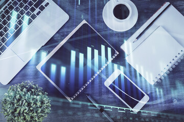 Naklejka premium Double exposure of forex chart hologram over desktop with phone. Top view. Mobile trade platform concept.