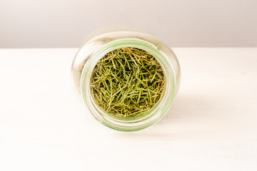 Dry Rosemary (Salvia rosmarinus) in a Jar on a White Table in Medellin, Antioquia / Colombia