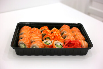 Philadelphia roll sets in a plastic box on the white background. Sushi delivery to the office