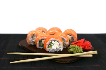 Philadelphia rolls with salmon on black table next to chopsticks. Japanese food concept