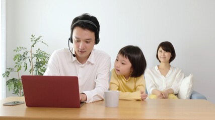 Obraz premium テレワークをするお父さんと家族