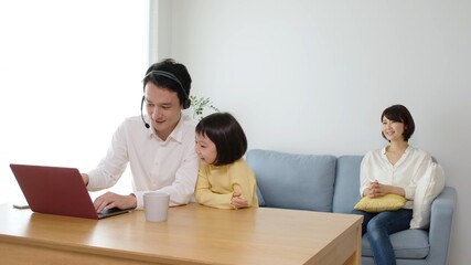 テレワークをするお父さんと家族