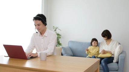 Obraz premium テレワークをするお父さんと家族
