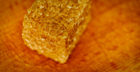A cube of brown soluble sugar on a wooden background, macro shooting