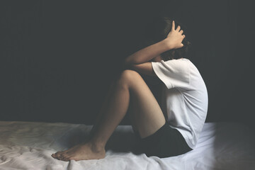 Sad little girl sitting in dark room. human trafficking concept.