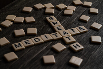 Meditate Breath Text. Flat lay photography - Word/s made with lettered tiles on timber background.