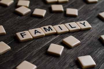 Family. Flat lay photography - Word/s made with lettered tiles on timber background.