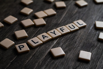 Playful Text. Flat lay photography - Word/s made with lettered tiles on timber background.
