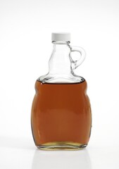 BOTTLE OF MAPLE SYRUP AGAINST WHITE BACKGROUND