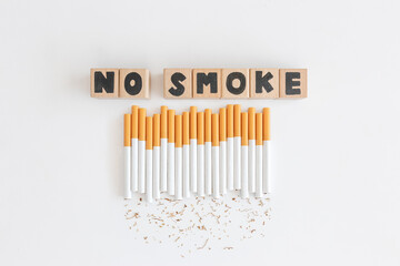 Overhead view of stop text wood cube from cigarette, Stop smoking initiative cubic wooded concept of breaking cigarettes,Top view no smoke text in wood block on white background, World no tobacco day.