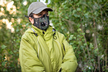 A girl wearing respirator mask walking in the forest protecting from COVID-19.