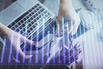 Double exposure of businesswoman hands typing on computer and financial graph hologram drawing. Stock market analysis concept.