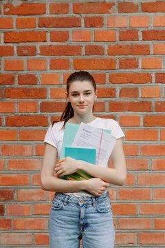 Confident female student with copybooks at campus