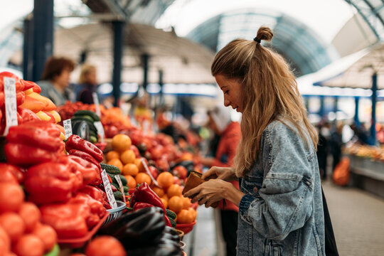 Woman buying fruits and vegetables on the market.