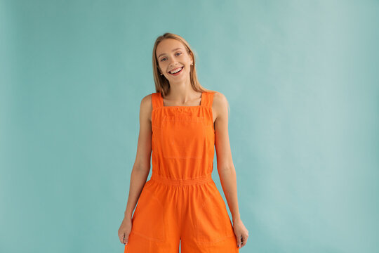Content teen blonde smiling on turquoise background
