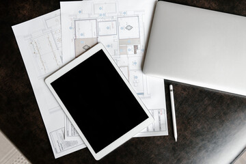 Workplace of modern engineer with tablet, plans and maps.