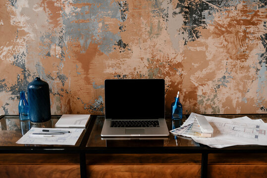 Workplace of engineer with laptop and maps.