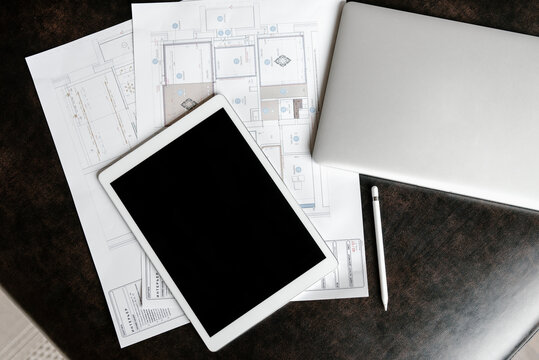 Workplace of modern engineer with tablet, plans and maps.