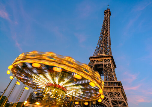 A Carousel Spins In Front Of The Eiffel Tower