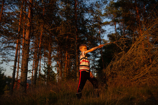 A boy plays expressively at dusk in rural Finland.