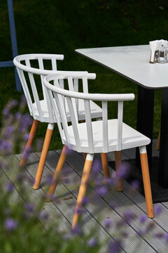 Wooden chairs painted in white at garden table