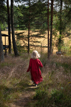 Wearing her mother's dress as she walks in rural Finland.