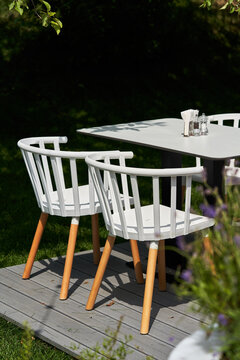Wooden chairs painted in white at garden table