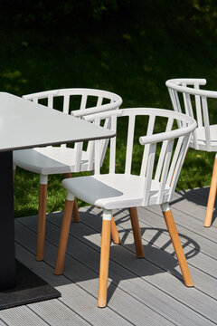 Wooden chairs painted in white at garden table