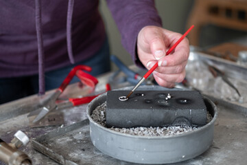 Woman making jewelry pendent