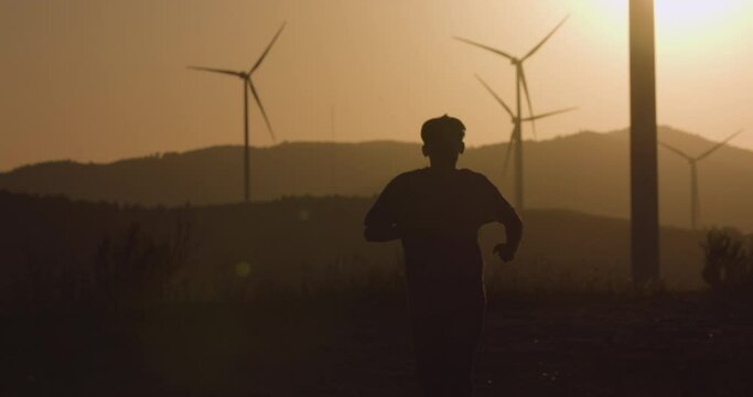 The guy runs towards the camera at sunset. Silhouette shooting.
