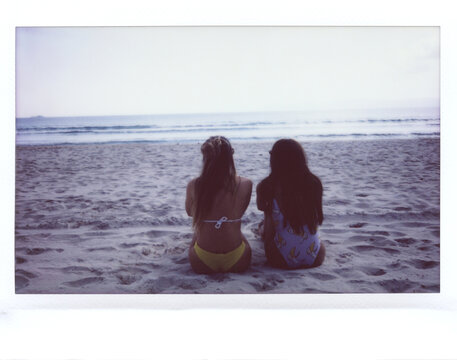 Two girls looking enjoying on sea waves.