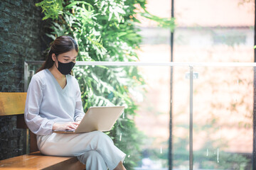 Asian business woman freelancer wearing surgical face mask, social distancing of the new normal lifestyle after epidemic of coronavirus COVID-19