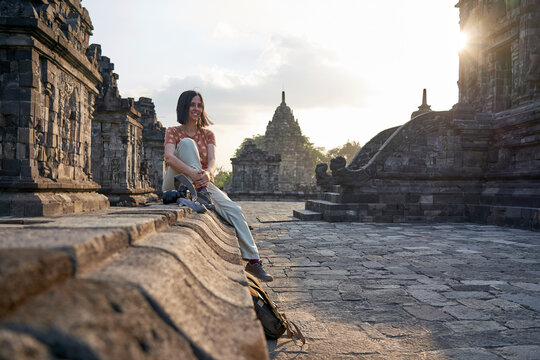 Woman with backpack enjoying the sunset in Prambanan Temple, Java, Indonesia