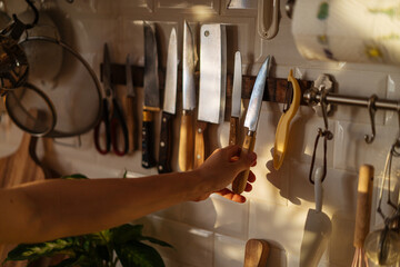 Person taking knife hanging on magnetic holder