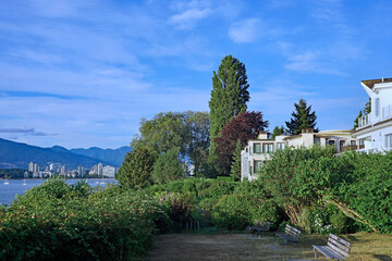 Fototapeta na wymiar Waterfront park in West Point Grey area of Vancouver, with distant view of city skyline