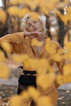 Pretty model in yellow jacket in autumn park