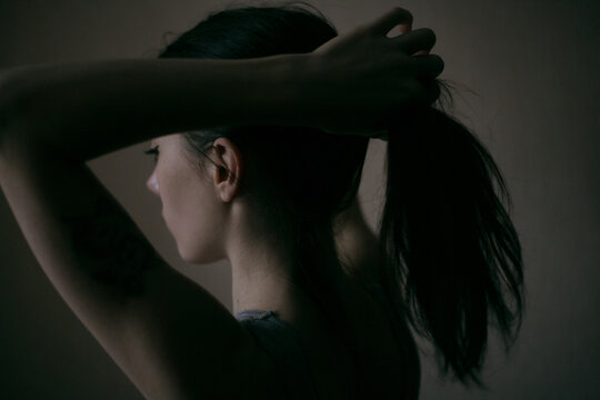 girl collects her hair in a bun