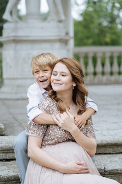 Happy boy hugging pregnant mother