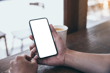 cell phone mockup image blank white screen.man hand holding texting using mobile on desk at coffee shop.background empty space for advertise.work people contact marketing business,technology