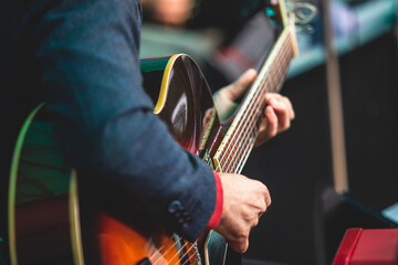Concert view of an electric acoustic guitar player with vocalist and musical jazz band orchestra...