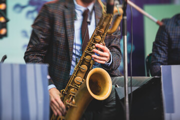 Naklejka premium Concert view of a saxophonist, saxophone player with vocalist and musical during jazz orchestra performing music on stage