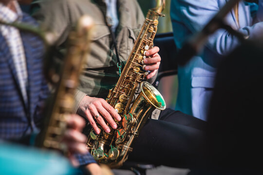 Concert view of a saxophonist, saxophone player with vocalist and musical during jazz orchestra performing music on stage
