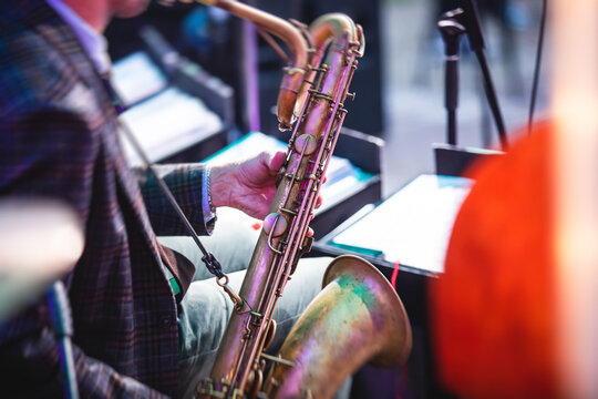 Concert view of a saxophonist, saxophone player with vocalist and musical during jazz orchestra performing music on stage