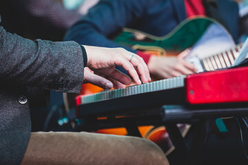 Concert view of a musical keyboard piano player during musical jazz band orchestra performing, keyboardist hands during concert, male pianist on stage, hands close up