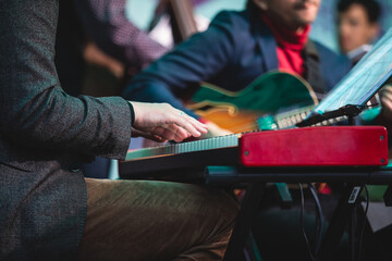 Concert view of a musical keyboard piano player during musical jazz band orchestra performing, keyboardist hands during concert, male pianist on stage, hands close up