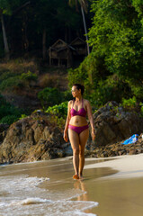 Woman traveler and bikini walk on beach