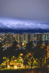 Panorama of amazing snowed Los Andes mountains,  sky with grey clouds over Santiago skyline,...