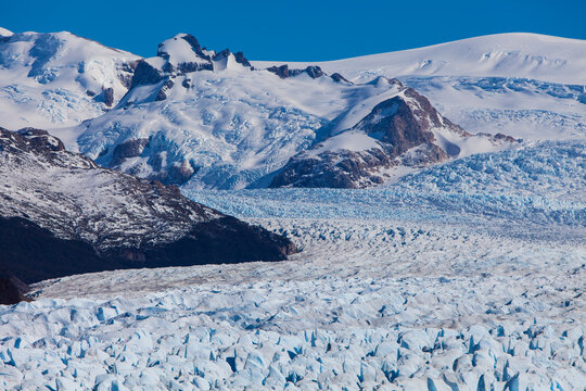 Carpet of ice rocks surrounded by snowy mountains at Perito Moreno Glacier in Argentina. Global warming and climate change concept.
