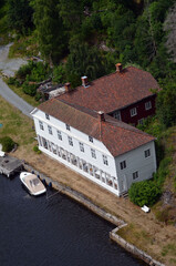 Fototapeta premium Typical Swedish nature and houses on the shore of the fjord. View from the high bridge over the fjord. The border of Norway and Sweden.Near the town Selater,Sweden